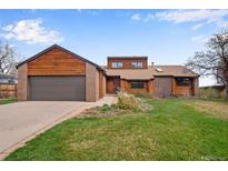 Charming single-Gathering home with brick and wood exterior, two-car garage, and well-maintained lawn in a quiet neighborhood at 11875 W 107Th Ave, Broomfield, CO 80021