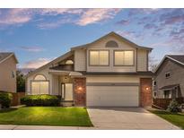 Charming two-story home with a well-manicured lawn and a brick-accented facade at 8985 Edgewood Ln, Highlands Ranch, CO 80130