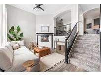 Bright living room with fireplace, staircase, modern decor, and plush seating at 3502 Nez Perce Trl, Castle Rock, CO 80109