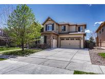 Inviting two-story home with a three-car garage, stone accents, and manicured front yard at 26566 E Peakview Dr, Aurora, CO 80016