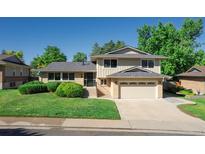Charming two-story home with a manicured lawn, mature trees, and a two car garage at 2931 S Sidney Ct, Denver, CO 80231