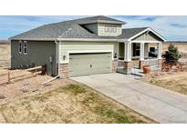 Charming two-story home with a gray roof, siding, a covered porch, and a spacious two-car garage at 42425 Forest Oaks Dr, Elizabeth, CO 80107