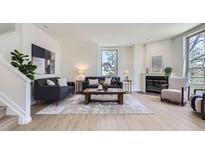 Bright living room featuring hardwood floors, modern decor, and a cozy fireplace, creating an inviting atmosphere at 2120 W 31St Ave, Denver, CO 80211