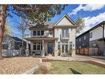 Charming two-story home with a welcoming front porch, stone accents, and a beautifully landscaped front yard at 2486 S Monroe St, Denver, CO 80210