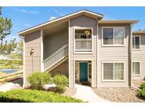 Inviting exterior of a two-story condo with a private entrance and a charming balcony, showcasing its appealing facade at 8405 Pebble Creek Way # 202, Highlands Ranch, CO 80126