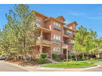 Charming multi-story condo with stone accents, lush landscaping, and signage at the corner of Oak Street at 10152 Inverness Main St, Englewood, CO 80112