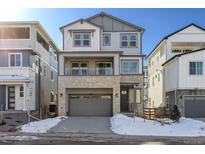 Two-story home with gray siding, stone accents, and a two-car garage at 8570 Eagle River St, Littleton, CO 80125