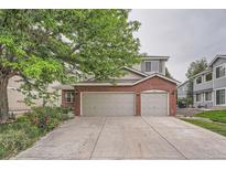 Two-story home with brick facade and spacious three-car garage and concrete driveway at 6526 S Killarney Ct, Aurora, CO 80016