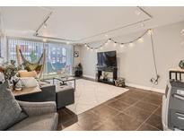 Inviting living room with neutral tones, tiled floor and modern track lighting perfect for relaxing or entertaining at 1155 Ash St # 202, Denver, CO 80220