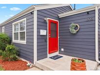 Charming home featuring a vibrant red front door and stylish gray wood siding at 1805 W 51St Ave, Denver, CO 80221