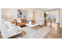Bright living room features modern decor, hardwood floors, and a sliding glass door to the outside at 1805 W 51St Ave, Denver, CO 80221