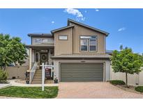 Two-story home featuring neutral siding, a two car garage, and a well-manicured front yard at 5153 Andes Way, Denver, CO 80249