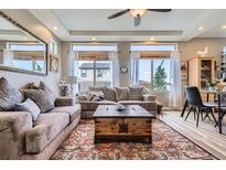 Cozy living room featuring neutral tones, large windows, and a decorative area rug at 5153 Andes Way, Denver, CO 80249