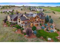 Stunning multi-story home with lush landscaping, stone accents, and an expansive outdoor living area and a water feature at 19155 Lochmere Ct, Monument, CO 80132