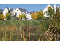 Exterior view of the community with grassy lawn, mature trees and a pond in the foreground at 6380 S Boston St # 191, Greenwood Village, CO 80111