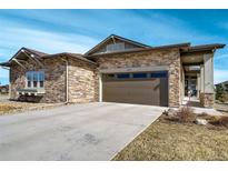 Beautiful single-story home featuring a stone facade, covered porch, and two-car garage at 25019 E Alder Dr, Aurora, CO 80016