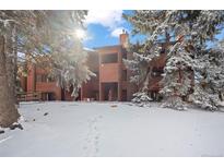 Inviting condo exterior surrounded by snow-covered trees on a sunny day at 1931 Centennial Dr # 1931, Louisville, CO 80027