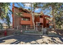 Inviting exterior of a wood-clad condo building with mature trees and well-maintained landscaping at 1931 Centennial Dr # 1931, Louisville, CO 80027