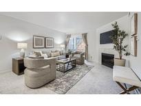 Bright living room featuring a fireplace, neutral furniture, and access to a balcony at 13093 W Cedar Dr # 121, Lakewood, CO 80228