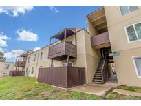 Tan apartment building featuring wood balconies and stairwell in outdoor setting at 9725 E Harvard Ave # 317, Denver, CO 80231
