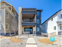 Modern three-story home boasts stone accents, a roof deck, and multiple balconies for outdoor enjoyment at 8633 Middle Fork St, Littleton, CO 80125