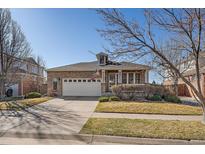 Charming brick home boasts a manicured lawn and a two-car garage at 20898 E Hamilton Ave, Aurora, CO 80013