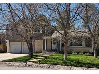Charming two-story home with attached two-car garage, brick and siding and a well-maintained lawn at 4609 S Kalispell Way, Aurora, CO 80015