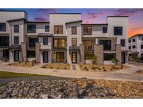 Modern townhome exterior with stone accents, black trim, and professional landscaping at 2076 S Holly St # 1, Denver, CO 80222