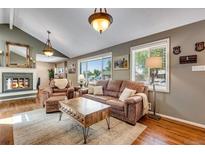 Inviting living room with hardwood floors, a cozy fireplace, and comfortable seating at 5620 E Cornell Ave, Denver, CO 80222