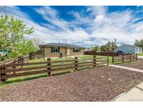 Charming single-story home featuring a brick exterior and a rustic wooden fence at 710 4Th St, Bennett, CO 80102
