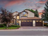 Charming two-story home with a three-car garage and stone accents, set against a beautiful sunset sky at 10954 W 100Th Way, Broomfield, CO 80021