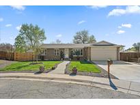 Charming brick home features a manicured front lawn and an attached two-car garage at 11707 W 65Th Cir, Arvada, CO 80004