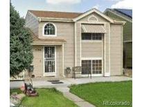 Two-story house with a beige exterior, lawn, and attached garage at 4396 Netherland St, Denver, CO 80249