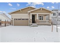 Attractive craftsman style home with a snow covered front yard at 3254 Boral Owl Dr, Brighton, CO 80601