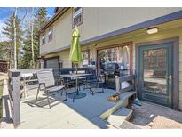 Outdoor deck features patio table, umbrella, grill, and exterior entrance to the house at 33 L Rd, Golden, CO 80403