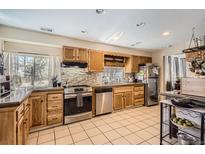Traditional-style kitchen with oak cabinets, tile backsplash and stainless steel appliances at 33 L Rd, Golden, CO 80403