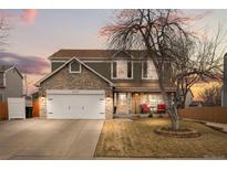 Charming two-story home featuring a stone facade, inviting porch, and a well-manicured front yard at 2924 E 116Th Pl, Thornton, CO 80233