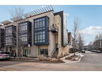 Contemporary townhome with large windows and a modern design featuring a small balcony and rooftop deck structure at 6946 W Alaska Dr, Lakewood, CO 80226