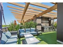 Inviting rooftop deck with comfortable seating, outdoor kitchen, pergola and turf creating a perfect oasis for relaxation at 6946 W Alaska Dr, Lakewood, CO 80226
