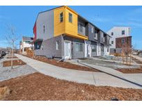 Modern townhome featuring a unique design with multi-tone exterior, neat front yard, and inviting entrance at 15295 W 68Th Pl, Arvada, CO 80007