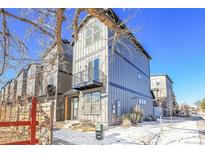 Modern three-story townhome with gray siding and a balcony at 6025 Ames St # A, Arvada, CO 80003