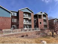 Brick condominium building featuring blue siding and white balconies on each level at 2675 S Danube Way # 302, Aurora, CO 80013