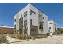 Modern townhome with mixed siding, brick accents, and large windows under a clear blue sky at 4100 E Iliff Ave # 4, Denver, CO 80222