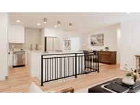 Open-concept living space with hardwood floors, modern finishes, and stainless steel appliances at 2257 S Lowell Blvd, Denver, CO 80219