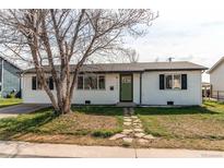 Charming home featuring stone pathway, green door, black trimmed windows, and tidy lawn at 280 Birch St, Bennett, CO 80102