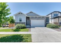 Charming single-Gathering home featuring stone accents, a two-car garage, and manicured front lawn at 4776 Kipp Pl, Brighton, CO 80601