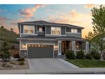 Beautiful two-story home with a well-manicured lawn and a welcoming front porch under a colorful sky at 1133 Lucky Ct, Castle Rock, CO 80109