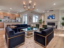 Spacious living room featuring a fireplace, a large window, and an open floor plan to the kitchen at 8018 Williams Fork Ave, Littleton, CO 80125