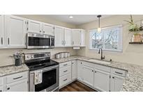 Bright kitchen features white cabinets, granite counters, stainless steel appliances, and modern fixtures at 20349 E Powers Pl, Centennial, CO 80015