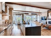 Open-concept kitchen featuring a large island, modern appliances, and seamless flow to the adjacent living area at 14115 Blue Stem St, Broomfield, CO 80020